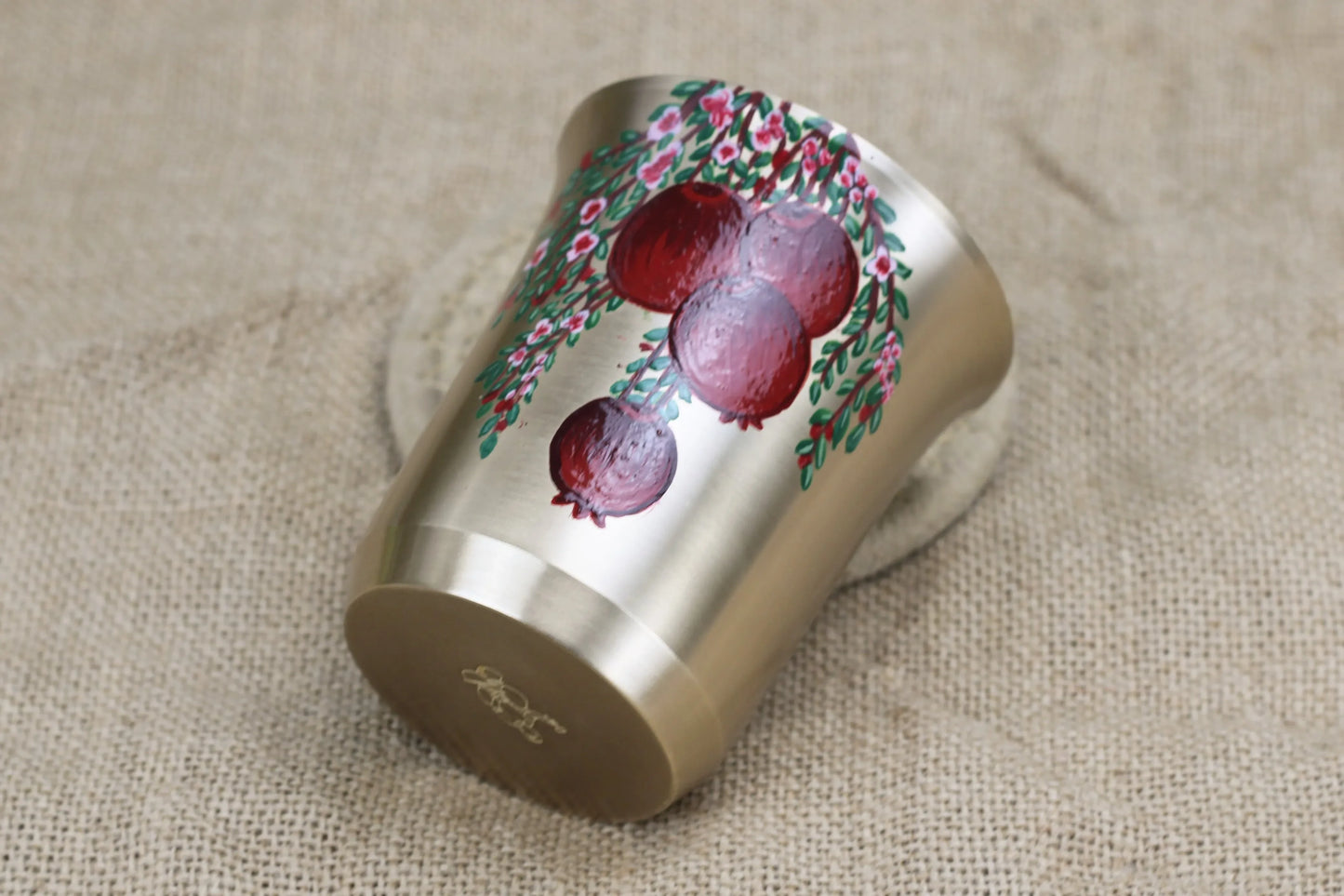 Hand-painted bronze tumbler with pomegranate design by Kansyakar, 220ml matte finish glass for daily use and gifting.