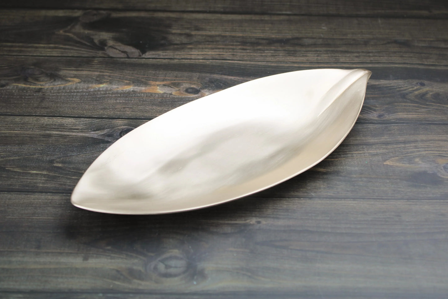 Bronze leaf-shaped serving platter by Kansyakar with matte and glossy finishes, ideal for elegant dining and home decor.