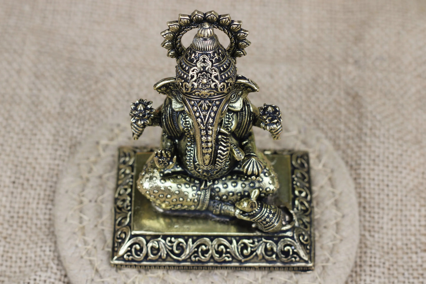 Simple brass Ganesha idol with long trunk seated on a singhasan, crafted by Kansyakar, weight 140 gm, size 6.5×4.5×8 cm.
