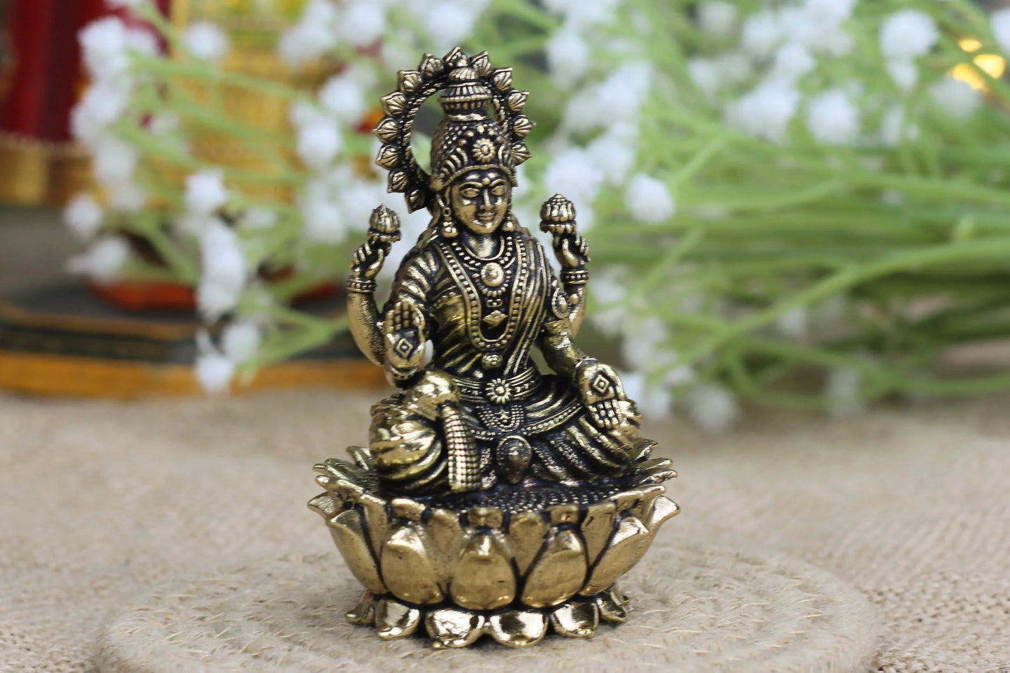 Small brass Sitting Lakshmi idol with antique finish, handcrafted for puja and home décor by Kansyakar.