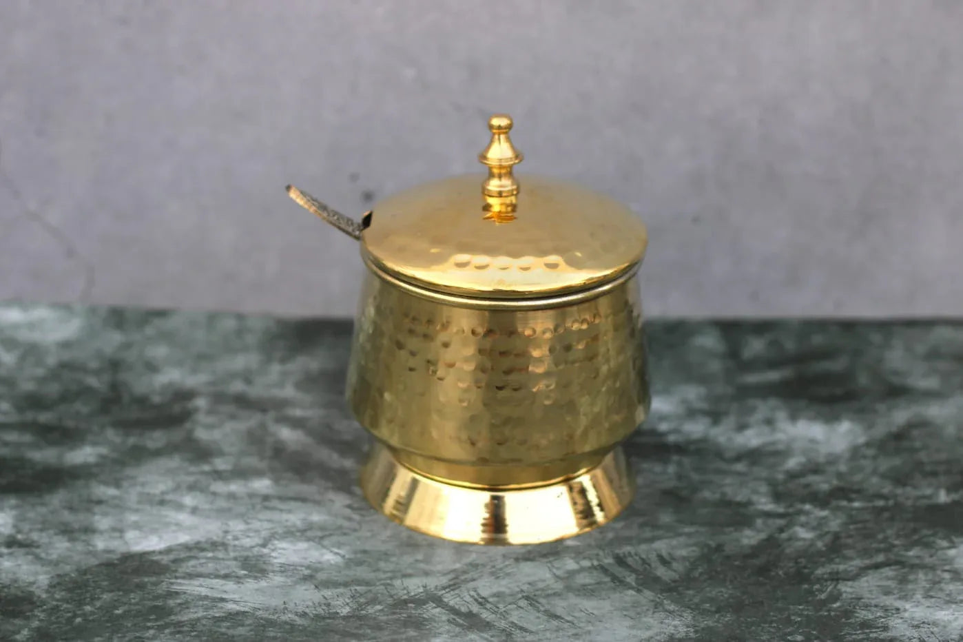 Hammered brass ghee/oil pot with tin coating and designer spoon, 250 ml capacity, crafted by Kansyakar in pure brass.