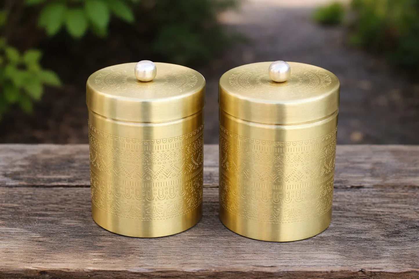 Two decorative brass storage jars with etched designs, airtight lids, ideal for kitchen storage of dry fruits and spices.