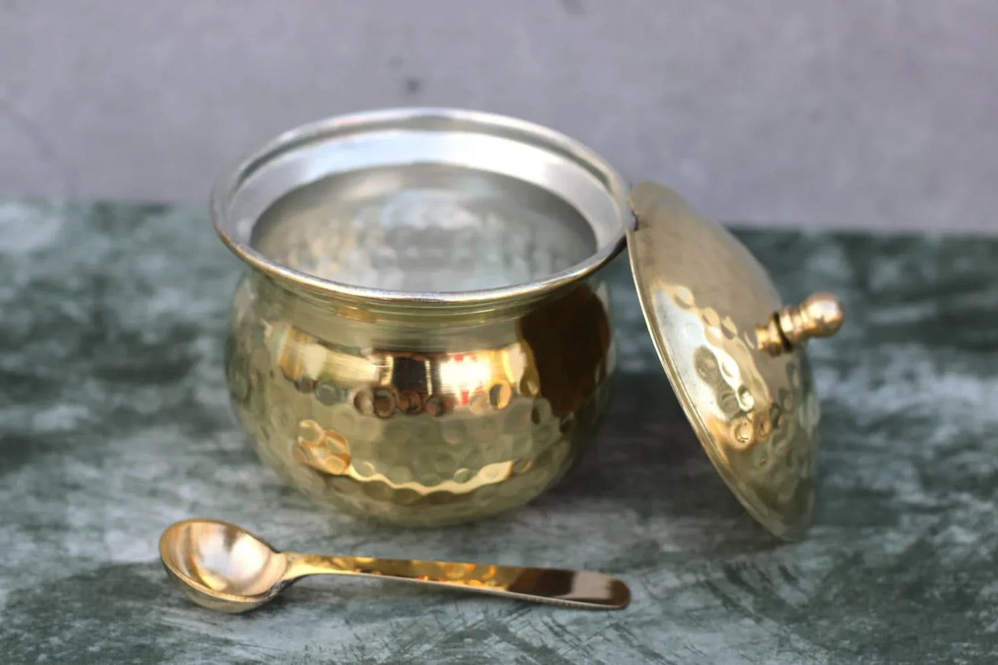 Traditional brass ghee pot with hammered finish, 250ml oil container with spoon, by Kansyakar, ideal for storing ghee or oil.